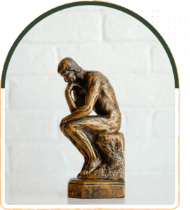 A bronze statue appears in quiet contemplation, with a textured surface, suggesting thought and inner reflection