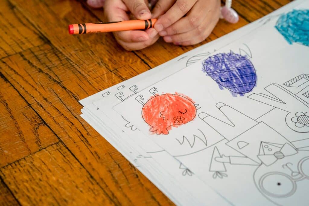 Child coloring with crayons during a pediatric neuropsychological evaluation to assess learning, attention, and fine motor skills