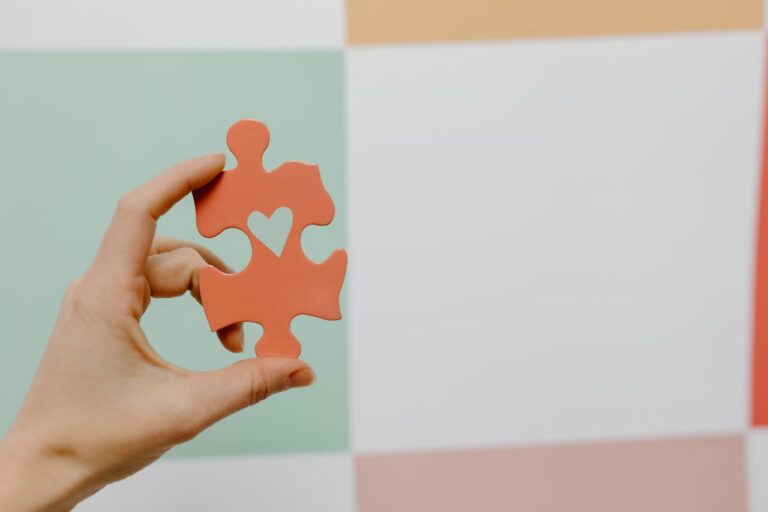 Hand holding puzzle piece with heart symbol representing ADHD evaluation support and neuropsychological assessment for children in Bellevue Seattle