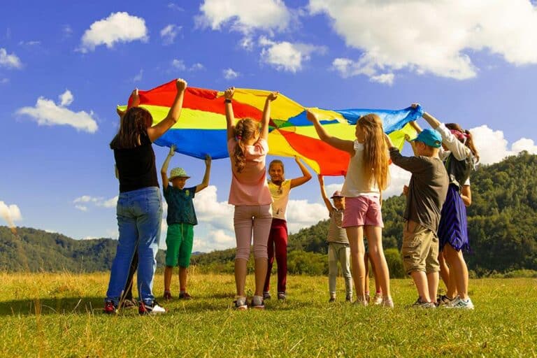 A group of children standing on a green grass field during daytime.